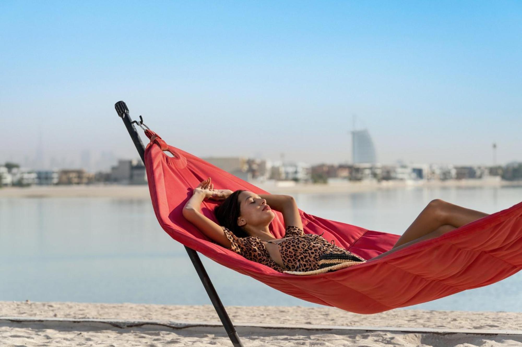 Th8 Palm Dubai Beach Resort, Vignette Collection By Ihg Exterior photo A woman relaxing in a hammock